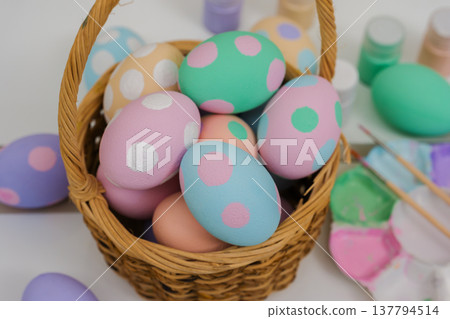 many colorful pastel decorated easter eggs in small wooden basket and watercolor painting tool on table many colorful pastel decorated easter eggs in small wooden basket and watercolor painting tool on table 137794514