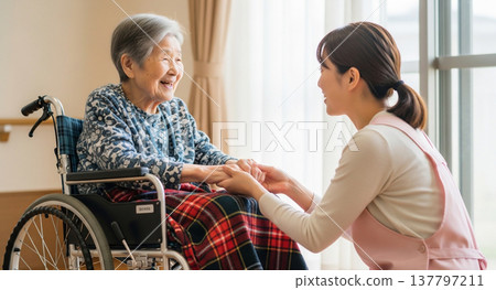 一名護理人員正在幫助一位坐在輪椅上的老婦人。 一名護理人員正在幫助一位坐在輪椅上的老婦人。 137797211