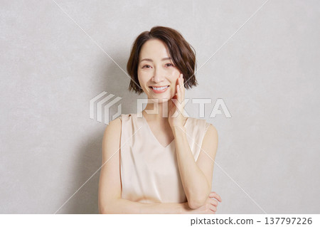 Middle-aged woman portrait gray background looking at camera 137797226
