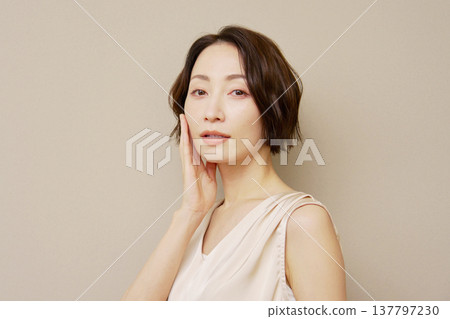 Middle-aged woman portrait brown background looking at camera 137797230