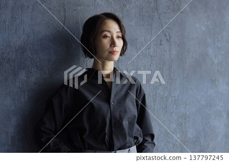Businesswoman standing against a black background Businesswoman standing against a black background 137797245