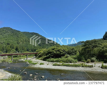 這裡自然風光優美,有藍天、山和河流。 這裡自然風光優美,有藍天、山和河流。 137797471