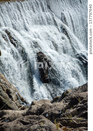 Water flows down the rugged rock face 137797640