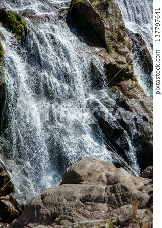 Water flows down the rugged rock face 137797641