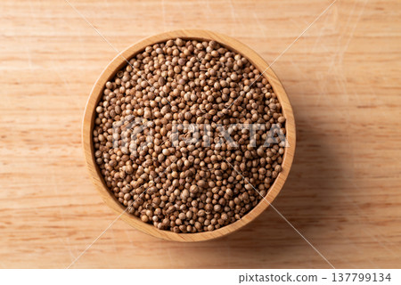 Coriander seeds in a bowl on wooden background, Thai food ingredients, Table top view Coriander seeds in a bowl on wooden background, Thai food ingredients, Table top view 137799134