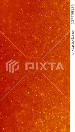Defocused glitter texture. Orange background. Warm vibrant color glimmer bright dazzle flow on acrylic art bokeh light abstraction. Defocused glitter texture. Orange background. Warm vibrant color glimmer bright dazzle flow on acrylic art bokeh light abstraction. 137799186