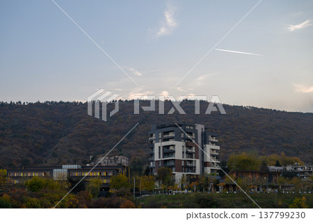 Modern Glass Office Building Against Forested Hillside, Cityscape Modern Glass Office Building Against Forested Hillside, Cityscape 137799230