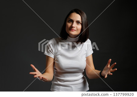 Young woman looking at camera with a confused expression and shrugging her shoulders in uncertainty. Young woman looking at camera with a confused expression and shrugging her shoulders in uncertainty. 137799920