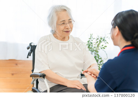醫院和養老院裡，坐輪椅的老人和護理人員（助理和物理治療師）交談 137800120