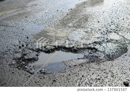 道路上形成的坑洞(瀝青路面上的孔洞) 道路上形成的坑洞(瀝青路面上的孔洞) 137801587
