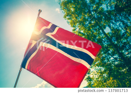Norwegian flag fluttering against blue sky Norwegian flag fluttering against blue sky 137801713