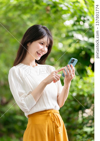一個有智能手機的女人，新鮮的綠色 137801774