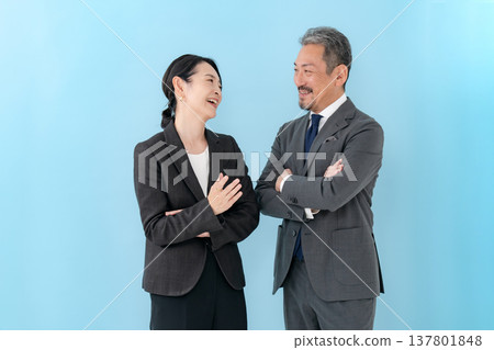 商業場合,一男一女,雙臂交叉,正在交談 商業場合,一男一女,雙臂交叉,正在交談 137801848