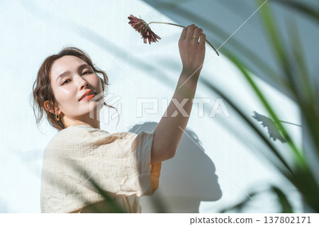 一位女子手捧一朵非洲菊 137802171