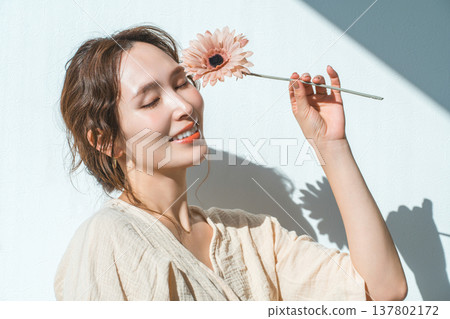 一位女子手捧一朵非洲菊 一位女子手捧一朵非洲菊 137802172
