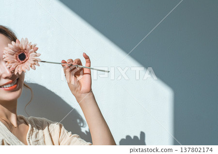 A woman holding a single gerbera flower A woman holding a single gerbera flower 137802174
