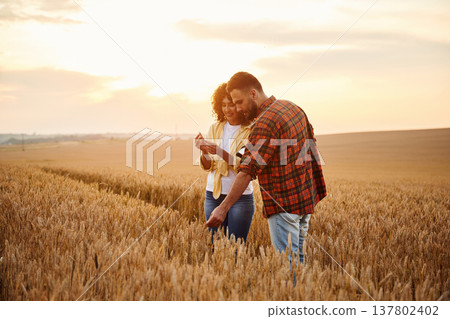 Taking a look at wheat piece. Two workers are on the agricultural field together 137802402