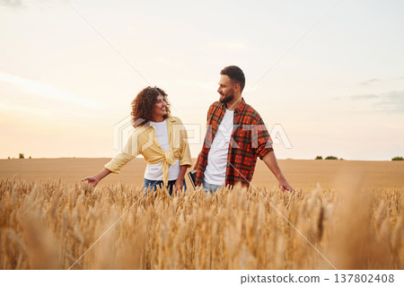 Two workers are on the wheat agricultural field together 137802408