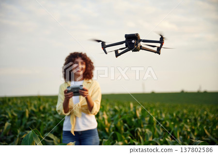 Professional drone operator. Woman is on the corn agricultural field 137802586