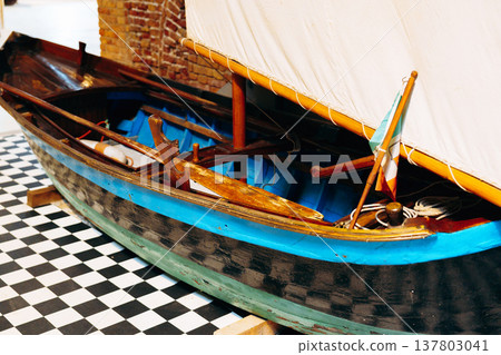 Model boat displayed inside a building on a checkered floor with a wooden frame Model boat displayed inside a building on a checkered floor with a wooden frame 137803041