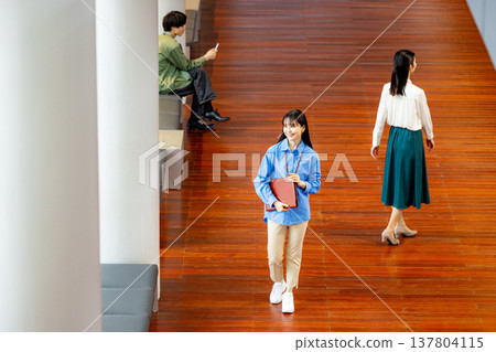 一位女商人正沿著走廊走著。 137804115