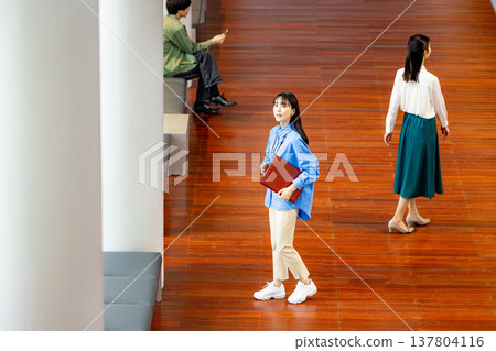 一位女商人正沿著走廊走著。 137804116
