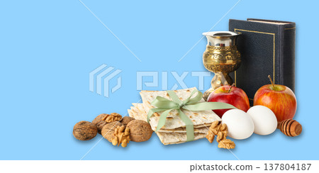Matzah, apples, eggs, and a cup are arranged for Passover 137804187