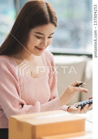 Starting small businesses SME owners female entrepreneurs check online orders to prepare to pack the boxes, sell to customers, sme business ideas online. 137804253
