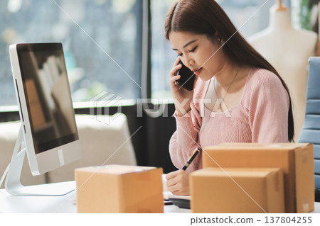 Starting small businesses SME owners female entrepreneurs check online orders to prepare to pack the boxes, sell to customers, sme business ideas online. 137804255