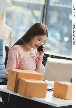 Starting small businesses SME owners female entrepreneurs check online orders to prepare to pack the boxes, sell to customers, sme business ideas online. Starting small businesses SME owners female entrepreneurs check online orders to prepare to pack the boxes, sell to customers, sme business ideas online. 137804256