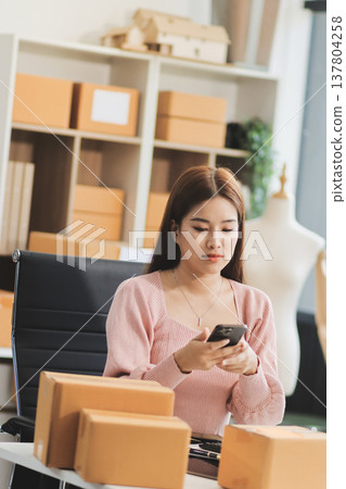 Starting small businesses SME owners female entrepreneurs check online orders to prepare to pack the boxes, sell to customers, sme business ideas online. Starting small businesses SME owners female entrepreneurs check online orders to prepare to pack the boxes, sell to customers, sme business ideas online. 137804258