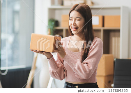 Starting small businesses SME owners female entrepreneurs check online orders to prepare to pack the boxes, sell to customers, sme business ideas online. 137804265