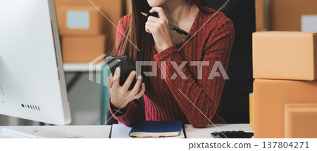 Starting small businesses SME owners female entrepreneurs check online orders to prepare to pack the boxes, sell to customers, sme business ideas online. 137804271