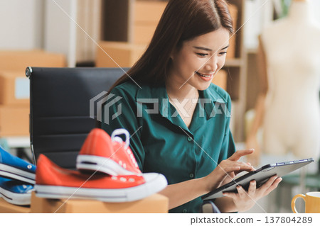 Starting small businesses SME owners female entrepreneurs check online orders to prepare to pack the boxes, sell to customers, sme business ideas online. Starting small businesses SME owners female entrepreneurs check online orders to prepare to pack the boxes, sell to customers, sme business ideas online. 137804289