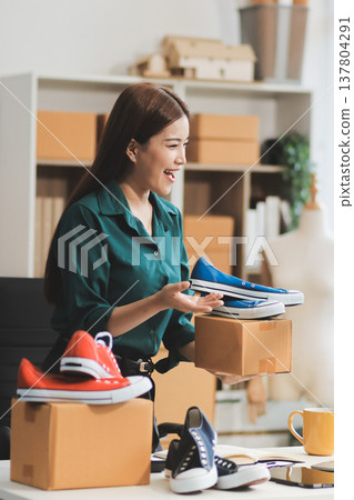 Starting small businesses SME owners female entrepreneurs check online orders to prepare to pack the boxes, sell to customers, sme business ideas online. Starting small businesses SME owners female entrepreneurs check online orders to prepare to pack the boxes, sell to customers, sme business ideas online. 137804291
