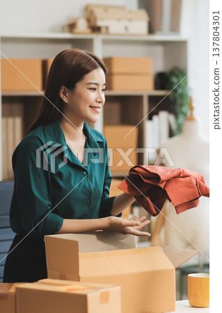 Starting small businesses SME owners female entrepreneurs check online orders to prepare to pack the boxes, sell to customers, sme business ideas online. Starting small businesses SME owners female entrepreneurs check online orders to prepare to pack the boxes, sell to customers, sme business ideas online. 137804301