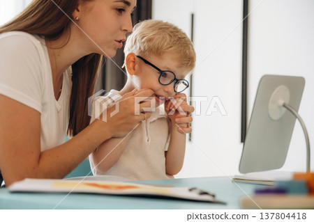 Speaking correctly, right way. Speech therapist is with young boy indoors 137804418