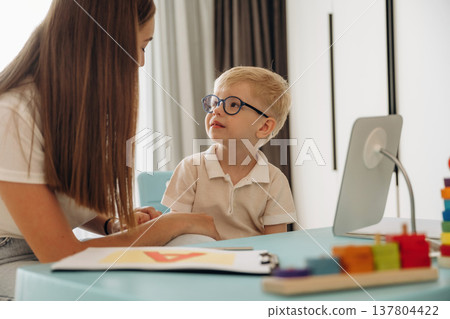 Speaking correctly, right way. Speech therapist is with young boy indoors 137804422