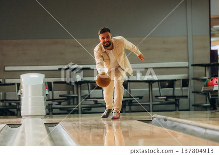Throwing the ball. Man is playing bowling indoors 137804913