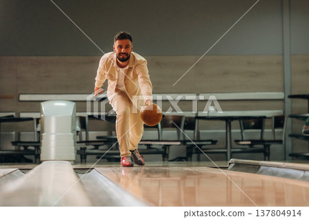 Throwing the ball. Man is playing bowling indoors 137804914