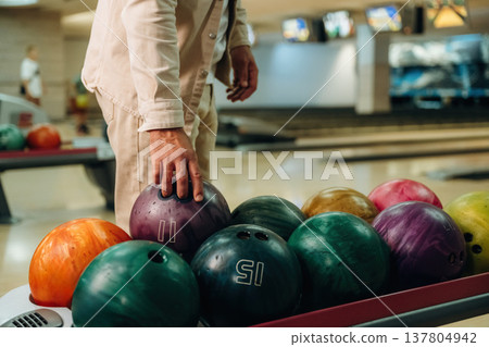 Taking the ball. Close up view of man that is playing bowling Taking the ball. Close up view of man that is playing bowling 137804942