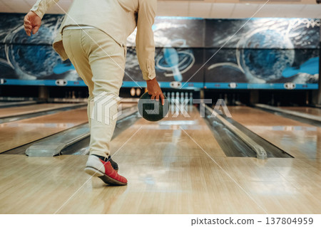 About to throw the ball. Close up view of man that is playing bowling 137804959