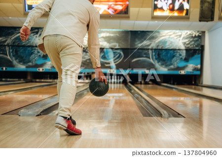 About to throw the ball. Close up view of man that is playing bowling 137804960