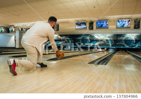 Running and throwing a ball. Man is playing bowling indoors 137804966