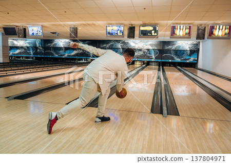 Running and throwing a ball. Man is playing bowling indoors Running and throwing a ball. Man is playing bowling indoors 137804971
