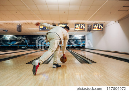 Man is playing bowling indoors Man is playing bowling indoors 137804972