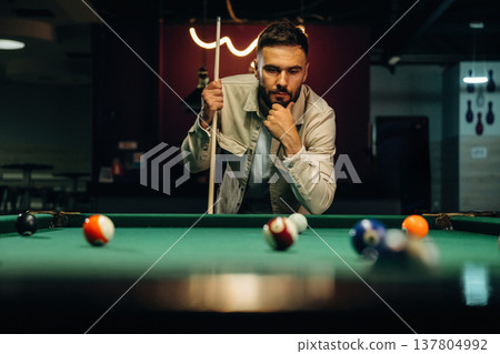 Handsome man with a pool table game Handsome man with a pool table game 137804992