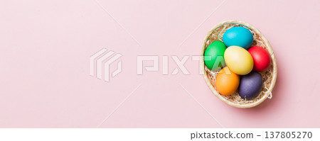 Multi colors Easter eggs in the woven basket on colored background . Pastel color Easter eggs. holiday concept with copy space 137805270