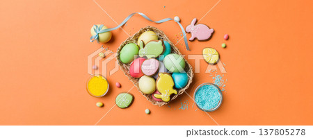 Colorful easter cookies in basket with Multi colors Easter eggs on colored background . Pastel color Easter eggs. holiday concept with copy space Colorful easter cookies in basket with Multi colors Easter eggs on colored background . Pastel color Easter eggs. holiday concept with copy space 137805278