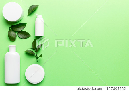 Organic cosmetic products with green leaves on color background. Copy space, flat lay 137805332